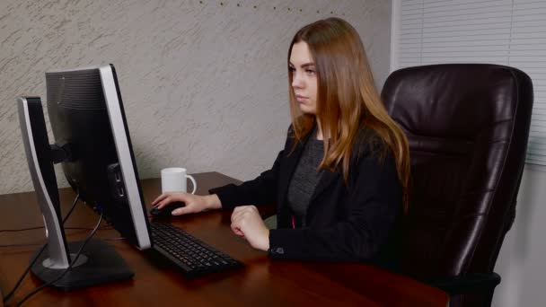 Молодая женщина работает с компьютером в офисе — стоковое видео