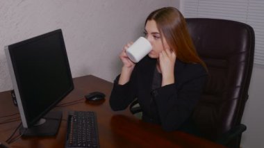 Genç kadın ofiste bilgisayar içme