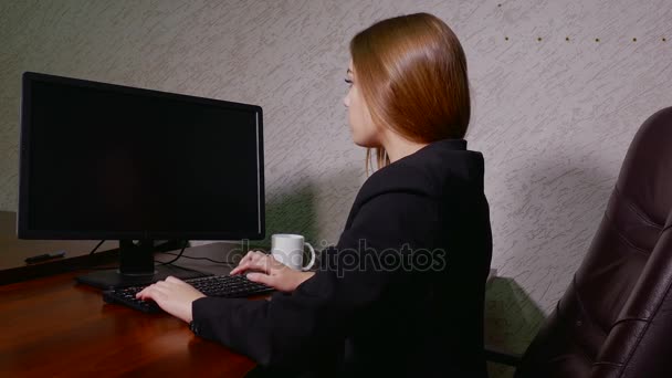 Обратный вид молодой женщины, работающей с компьютером — стоковое видео