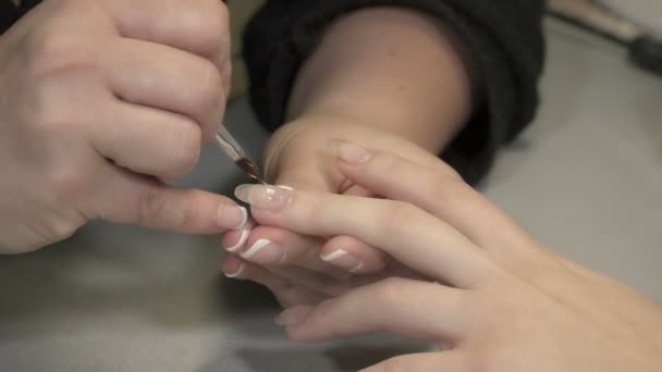 Closeup of manicure master hands taking care of girls nails — Stock Video