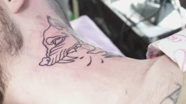 Tatooer boynuna hayvan dövme yapıyor