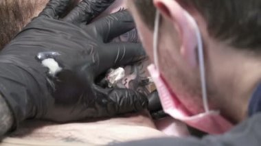 Maskeli Tatooer dövme dövme makinesi ile yapıyor