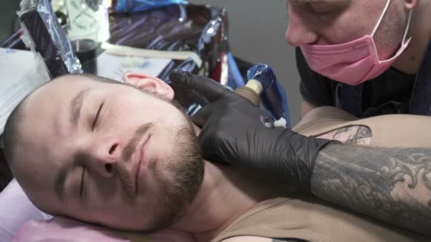 Tatoueur dans le masque fait tatoo sur le cou — Video