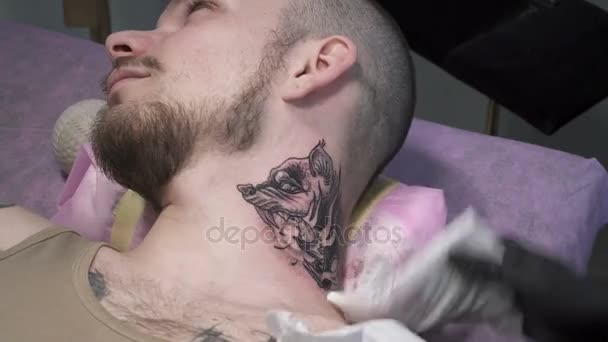 Tatooer está limpiando tatoo en el cuello — Vídeos de Stock