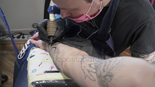 Un tatuaggio da colorare tatuatore sulla mano dell'uomo — Video Stock