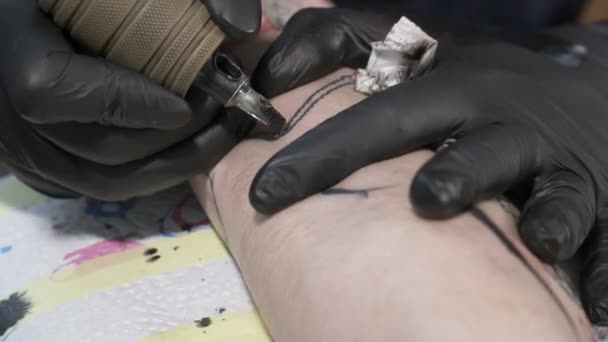 Tatooer is coloring tatoo on mans hand — Stock Video