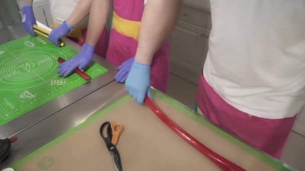 Виробництво карамельних цукерок і цукерок, два майстри розтягують карамельні цукерки — стокове відео