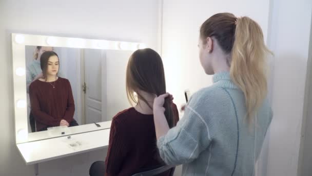 Mujer joven haciendo peinado al cliente — Vídeo de stock
