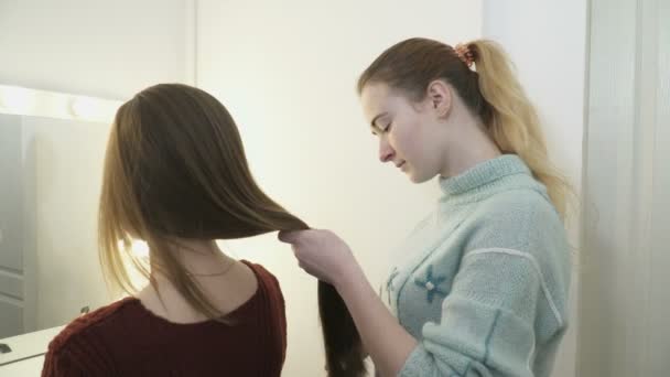 Jovem mulher pentear clientes cabelo no salão — Vídeo de Stock