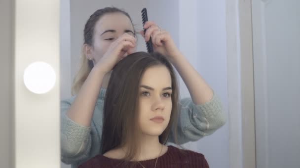 Reflexion einer jungen Frau, die ihren Kunden die Haare kämmt — Stockvideo