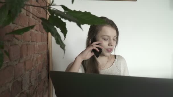 Tonåring flicka pratar i telefon internet café — Stockvideo