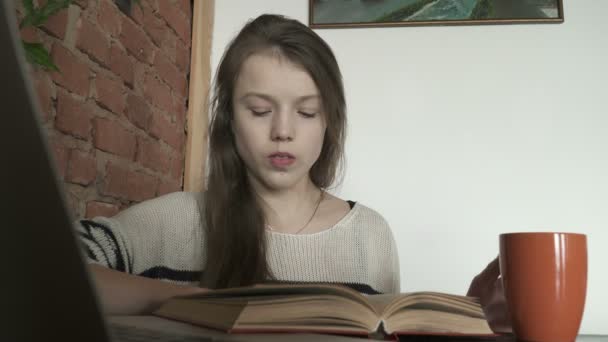 Primer plano de la adolescente leyendo un libro en la cafetería — Vídeo de stock