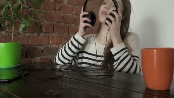 Closeup of remaja gadis mendengarkan musik di kafe — Stok Video