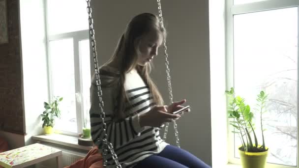 Teenager girl using tablet on swing — Stock Video