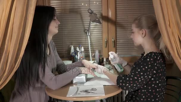 Manicura maestra cuidando las uñas de una joven — Vídeos de Stock