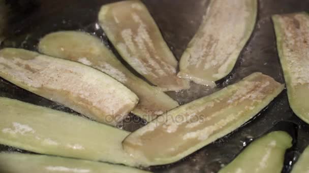 Close-up van gesneden aubergine frituren in de lichte olie — Stockvideo