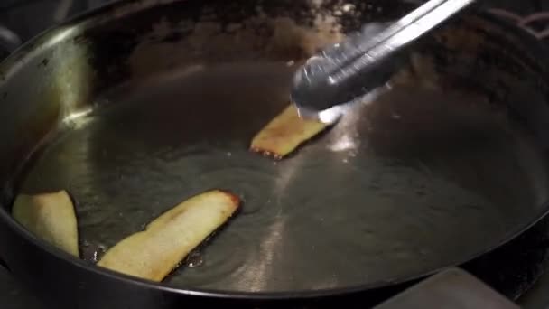 Cocinar poniendo berenjena en rodajas para freír en el aceite ligero — Vídeo de stock