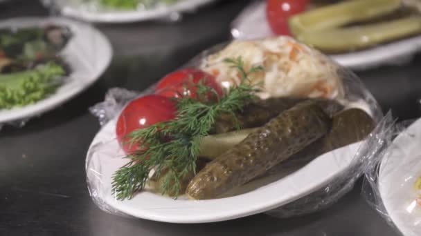 Közelkép a lédús fűszeres pácolt paradicsom, uborka és káposzta egy fehér lemezre — Stock videók