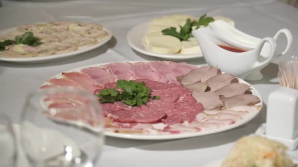 Различные виды мяса на белой тарелке на столе — стоковое видео