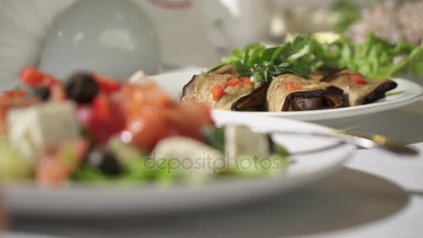Close-up van platen met Griekse salade geserveerd in de witte plaat — Stockvideo