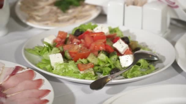Closeup pochoutkový salát a jídla podávaná v bílé desky na stůl