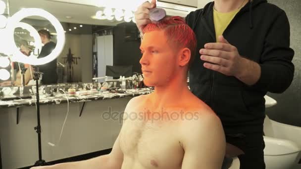 Makeup master covers models hair with orange color in the studio — Stock Video