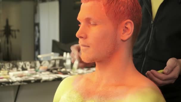 Gros plan de maquilleur créant du maquillage d'art pour un homme 