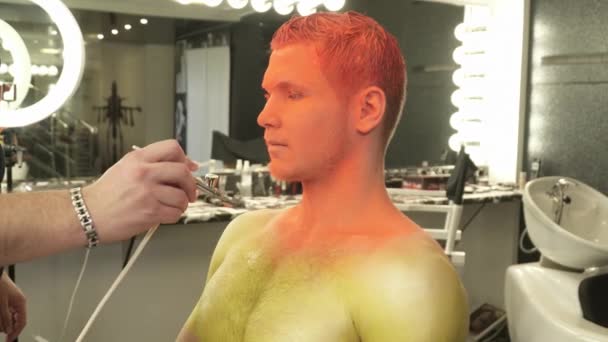 Τέχνη καλλιτέχνης μακιγιάζ που καλύπτει επανδρώνει το σώμα με το χρώμα από ένα aerograph — Αρχείο Βίντεο