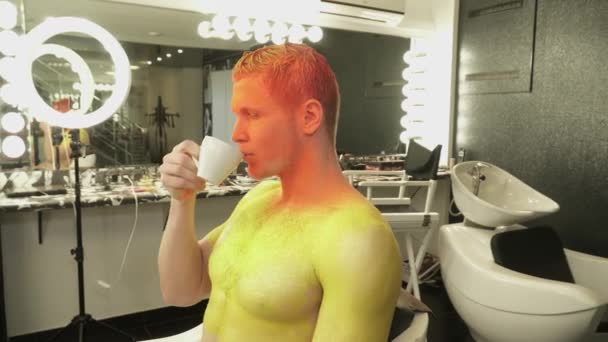 Man is art makeup is drinking coffee from a cup — Stock Video