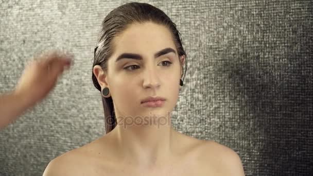 Maquillaje artista preparando chica para el arte del cuerpo, cubriendo el cabello con la cubierta de base — Vídeos de Stock