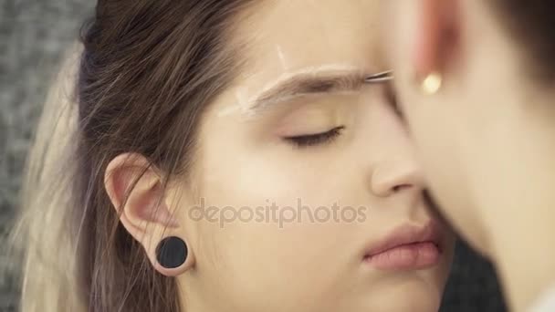 Kosmetikerin fixiert Augenbrauenform im Atelier — Stockvideo