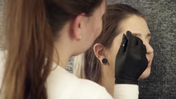 Artiste esthéticienne fixant la forme du sourcil droit — Video