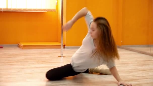 Молодая женщина исполняет красивые танцы вокруг шеста — стоковое видео