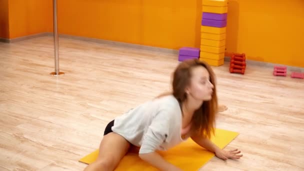 Jovem mulher se alongando em um tapete antes de dançar — Vídeo de Stock