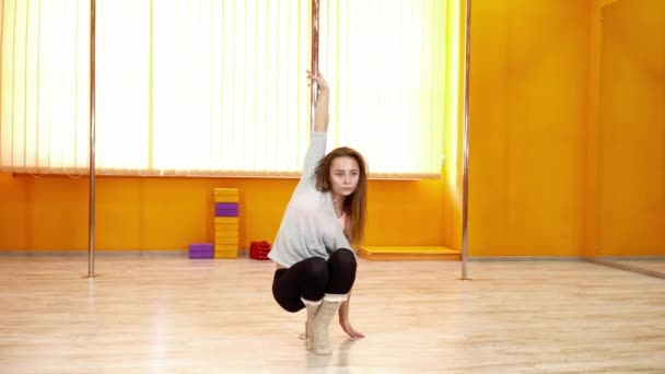 Giovane ballerina fare trucchi con il palo nella sala da ballo — Video Stock