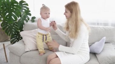 Genç anne küçük oğlu yürümeye yardımcı