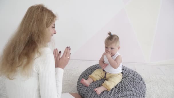 Joven madre aplaudiendo de la mano con su pequeño bebé, primer plano — Vídeos de Stock