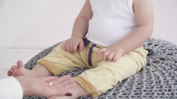 Jeune mère jouant avec son enfant quand il est assis sur le pouf, gros plan — Video