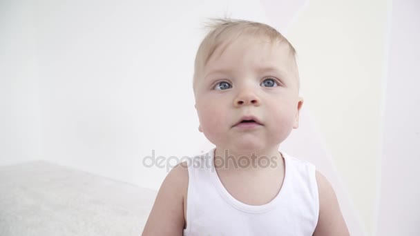Mały ładny chłopczyk patrząc na kamery i grać z nim — Wideo stockowe