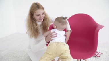 Genç anne bebek oğlu ile sandalyenin üstünde oynama