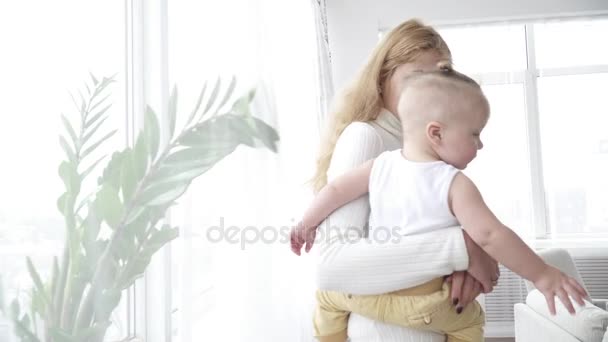 Mother looking at the window with her small baby boy — Stock Video