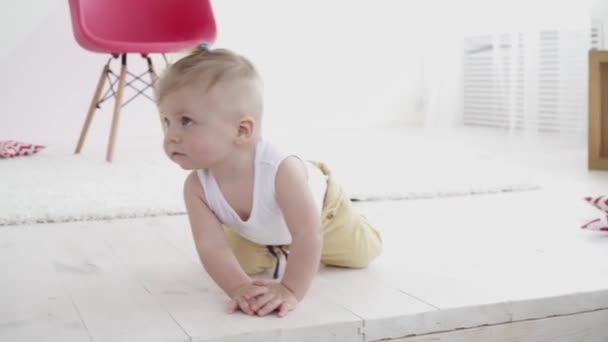Pequeño niño coronando en el suelo en la habitación — Vídeo de stock