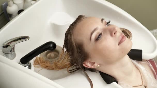 La peluquera lavando el pelo de las mujeres en la lavadora — Vídeo de stock