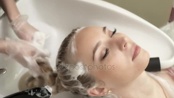 젊은 여 대 헤어 살롱에서 머리를 세척 하는 미용사 — 비디오