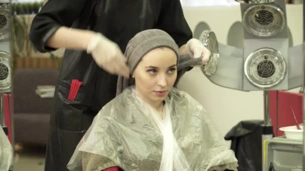 Młoda kobieta jest o procedurze włosów w salon fryzjerski — Wideo stockowe