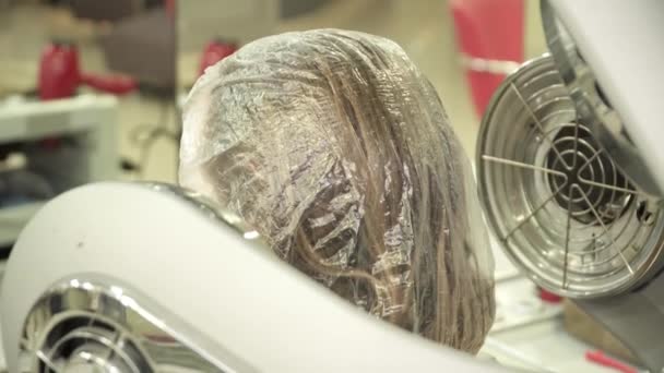 女性はマシン ビューの後ろからドライヤーで髪を乾燥します。 — ストック動画