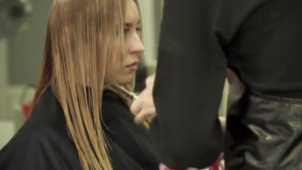 Peluquería está haciendo corte de pelo para una mujer en el salón — Vídeo de stock