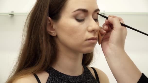 Schoonheidsspecialiste is de toepassing van de eye shadows in salon closeup — Stockvideo