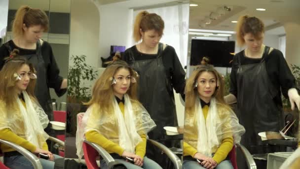 Молодая женщина красит волосы в парикмахерской — стоковое видео