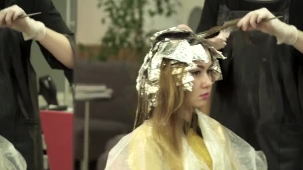 Estilista es teñir mujeres cabello en el salón — Vídeo de stock